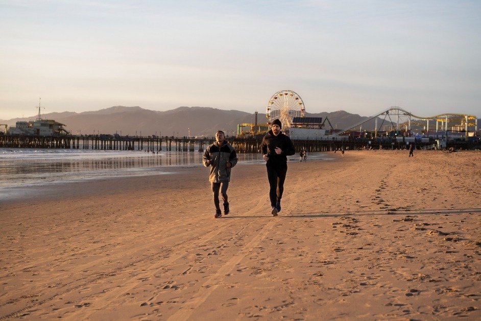 Venice Beach Boardwalk with palm trees, shops, and people walking in Los Angeles